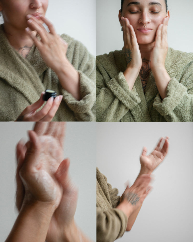 Four-panel grid — queer nonbinary model with light olive complexion in olive green robe: applying Lip Balm, pressing hands to face eyes closed, lathering hand wash, and spraying mist on tattooed forearm — botanical skincare morning ritual sequence